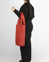 Bolso tote negro acolchado con doble asa de hombro.