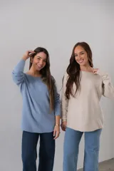 Sweater celeste de punto con corte recto y cuello redondo. Presenta detalle de líneas verticales formadas con el mismo hilado en la parte delantera.