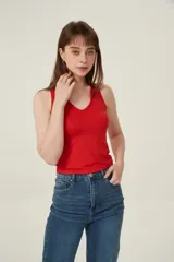 Musculosa roja de poliéster con bretel ancho, canalé, corte al cuerpo y cuello redondo.