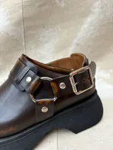 Zueco de cuero negro con plataforma de 4.5 cm, diseño moderno y hebilla ajustable.