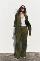 Blazer color verde oliva confeccionada en lino, con cuello solapa, manga tres cuartos con vuelta y cierre cruzado con botones.