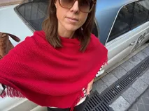 Poncho tejido en hilo de algodón color rojo, con terminaciones con flecos.