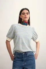 Remera a rayas horizontales azules y blancas, con mangas abullonadas y puños ajustados.