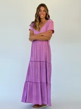 Vestido largo color lila con escote en V, mangas cortas y corte escalonado.