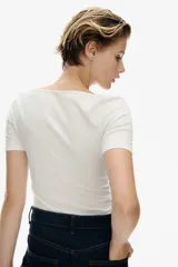 Remera cropped blanca de punto acanalado fino de algodón, con escote redondo amplio y bajo recto.
