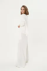 Pantalón palazzo color crudo, de morley térmico suavizado, con bolsillos laterales, cintura elastizada y cordón ajustable.