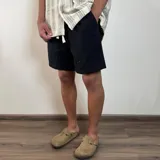 Bermuda negra de lino con corte arriba de la rodilla y cordón ajustable en la cintura.