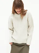 Sweater tejido con trenzas color beige claro, de corte holgado y cuello en V.
