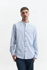 Camisa azul de manga larga con cuello mao y cartera abotonada.