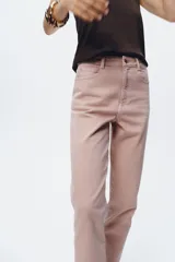 Pantalón de jean gris oscuro, de corte mom fit, tiro alto y largo tobillero. Cuenta con cinco bolsillos, cierre frontal con cremallera y botón.
