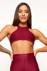 Top deportivo color bordó, con textura tipo panal 3D, cuello alto y estructura firme.