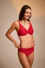 Top de bikini negro con breteles finos y detalle de nudo en el centro del busto.