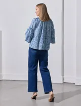 Blusa celeste con estampado floral blanco, escote con frunces y mangas 3/4 con volados.