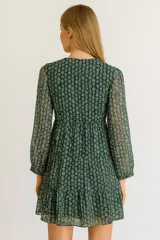 Vestido corto con estampado de hojas, escote en V y mangas largas.