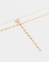 Set de dos collares dorados: uno corto de perlas sintéticas con dije de corazón dorado y otro largo con cadena de eslabones y dijes de corazones.