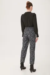 Pantalón babucha negro con estampado floral en tonos celeste y blanco.