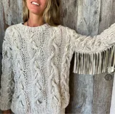 Sweater celeste de lana mohair con diseño de trenzas y apliques de cuero color suela.