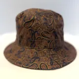 Gorro tipo bucket con estampado paisley en tonos marrones y negros.