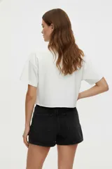 Remera blanca de algodón con estampado de texto y gráficos alusivos a la playa. Corte crop y cuello redondo.