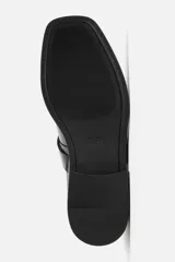 Zapato tipo Mary Jane de cuero negro con hebilla lateral, horma redonda y suela con ligero tacón.