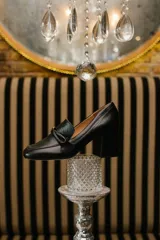 Zapato clásico de cuero azul marino, con aplique decorativo en el empeine y taco cuadrado.