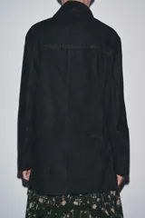 Chaqueta de ante negra con cuello solapa de muescas y manga larga. Tiene bolsillos con solapa en delantero y cierre frontal con botones.