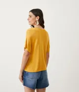 Blusa de punto color mostaza, con escote en V y mangas cortas.