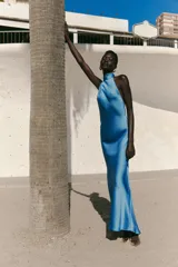 Vestido largo de satén color celeste, con cuello halter y espalda descubierta. Cierre trasero con cremallera oculta.