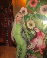 Vestido midi ajustado de microtul verde con estampado abstracto en tonos oscuros. De mangas largas y cuello redondo, es una prenda transparente y elástica.