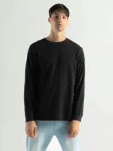 Remera negra de manga larga con cuello redondo, confeccionada en tejido mini piqué de algodón.