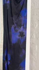 Vestido largo de fiesta con estampado floral en tonos azul y negro, escote halter y espalda descubierta.