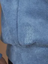 Campera con capucha de toalla de algodón color verde azulado, con cierre frontal y bolsillos laterales.