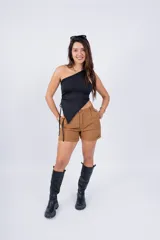 Top blanco de un solo hombro con corte asimétrico y cordón ajustable en el lateral.