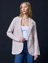 Blazer de lino color beige, marca Zac & Rachel. Tiene cuello con solapa, abertura central con botón, bolsillos delanteros y corte clásico.