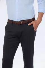 Pantalón de vestir azul marino, de corte recto, con bolsillos laterales y traseros. Se ajusta a la cintura con cinturón de cuero marrón.