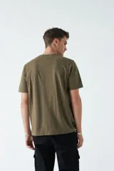 Remera verde militar de corte clásico con estampado frontal de texto en color ladrillo y dibujo de hojas.