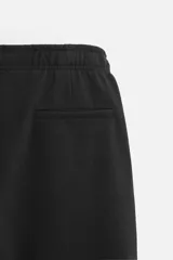 Pantalón de jogging color beige confeccionado en tejido de mezcla de algodón. Cuenta con cintura elástica ajustable con cordón, bolsillos frontales y traseros.