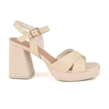 Sandalias de cuero color beige con plataforma y taco cuadrado. Presentan tiras cruzadas en el empeine y pulsera con hebilla al tobillo.