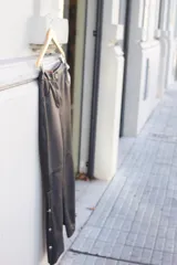 Pantalón de cuero genuino ovino color negro, de corte recto y tiro alto, con tajo lateral en la pierna que se abre mediante botones plateados.