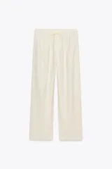 Pantalón jogger wide leg color crudo, confeccionado en hilatura con lino. Tiro medio, cintura elástica ajustable con cordones, bolsillos laterales ocultos en costura y pierna ancha.