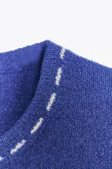 Top azul de tejido de punto con cuello redondo y manga corta. Detalle de pespuntes blancos a contraste en cuello, mangas y ruedo.