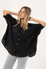 Camisa negra con calados, escote en V, abotonada y manga 3/4.