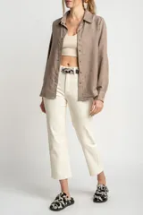 Camisa color marrón claro de gamuza vegana con calce oversize, cuello clásico, cierre frontal con botones y mangas largas con puños abotonados.
