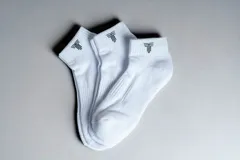Pack de tres pares de medias soquete blancas con logo negro en el tobillo.