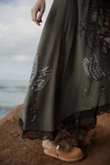 Vestido largo verde militar de seda, con breteles finos y escote en V con puntilla negra. Estampado inferior con motivos italianos.