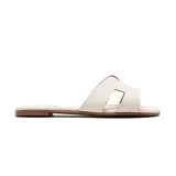 Sandalia casual baja color blanco con tira ancha en el empeine con abertura geométrica.