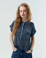 Remera azul de lino con cuello mao, media cartera con broches metálicos, manga japonesa y bolsillo plaqué en el delantero.