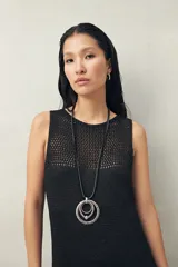 Vestido largo tejido de punto calado color negro, de corte recto y sin mangas.