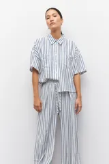 Pantalón largo azul con rayas verticales blancas, de corte amplio, con cintura elastizada y cordón ajustable.
