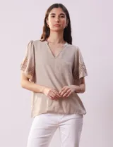 Blusa color beige de crepe, marca Batía, con cuello a la base y escote en V. Manga corta amplia con bordados.